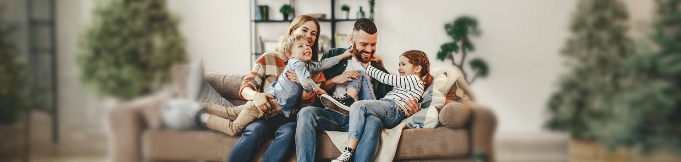 happy family mother father and kids at home on the couch