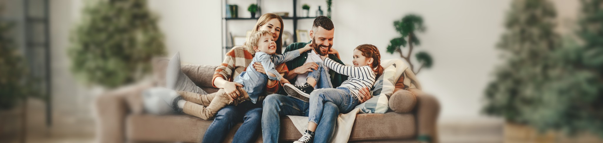 happy family mother father and kids at home on the couch
