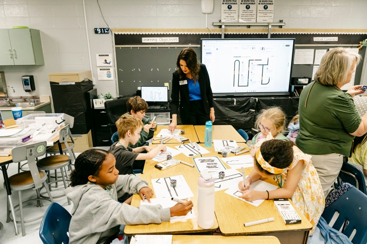 Taylor Rice, SRNS Education Outreach Lead, center, interacts with elementary and middle school students using programmable robots. Ozobot Ari features sensors for motion and distance, allowing students to program behaviors, solve puzzles, and engage with lessons in subjects like math, science and artificial intelligence.